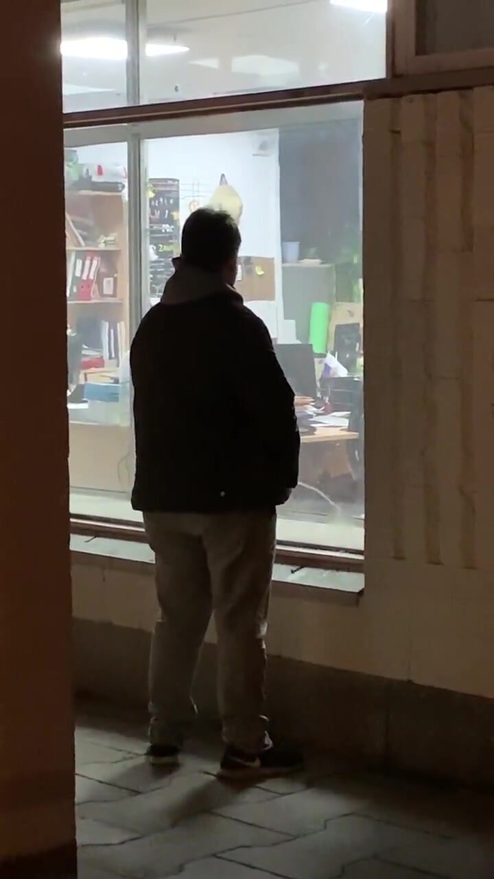 Guy pissing on North Korean office window