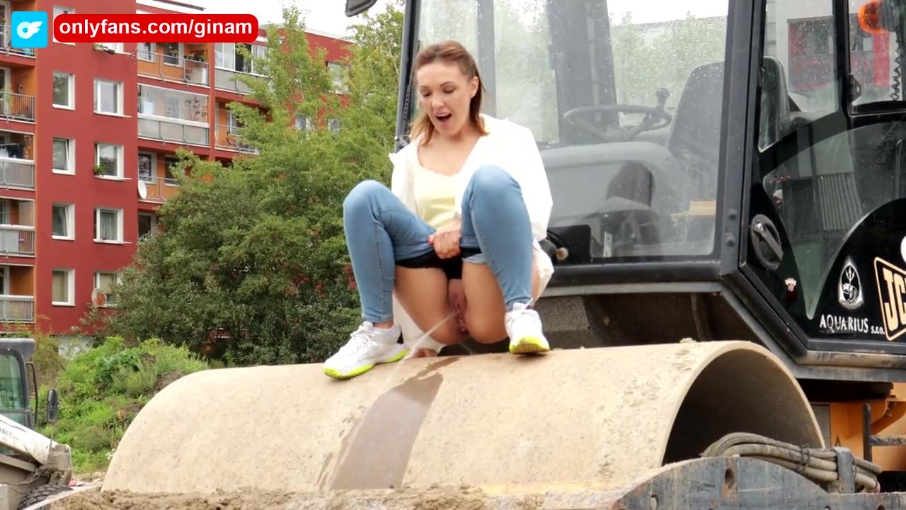 Girl pees off of a construction vehicle