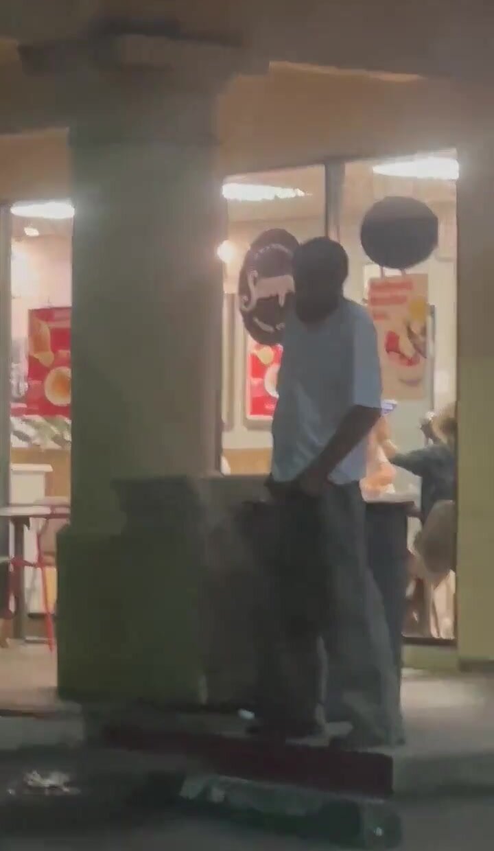Homeless guy pisses outside of pizza shop