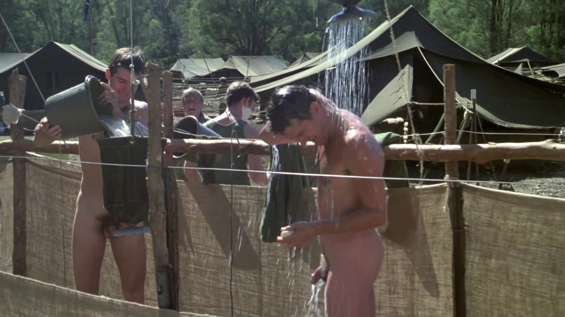 Naked actors shower in a military camp