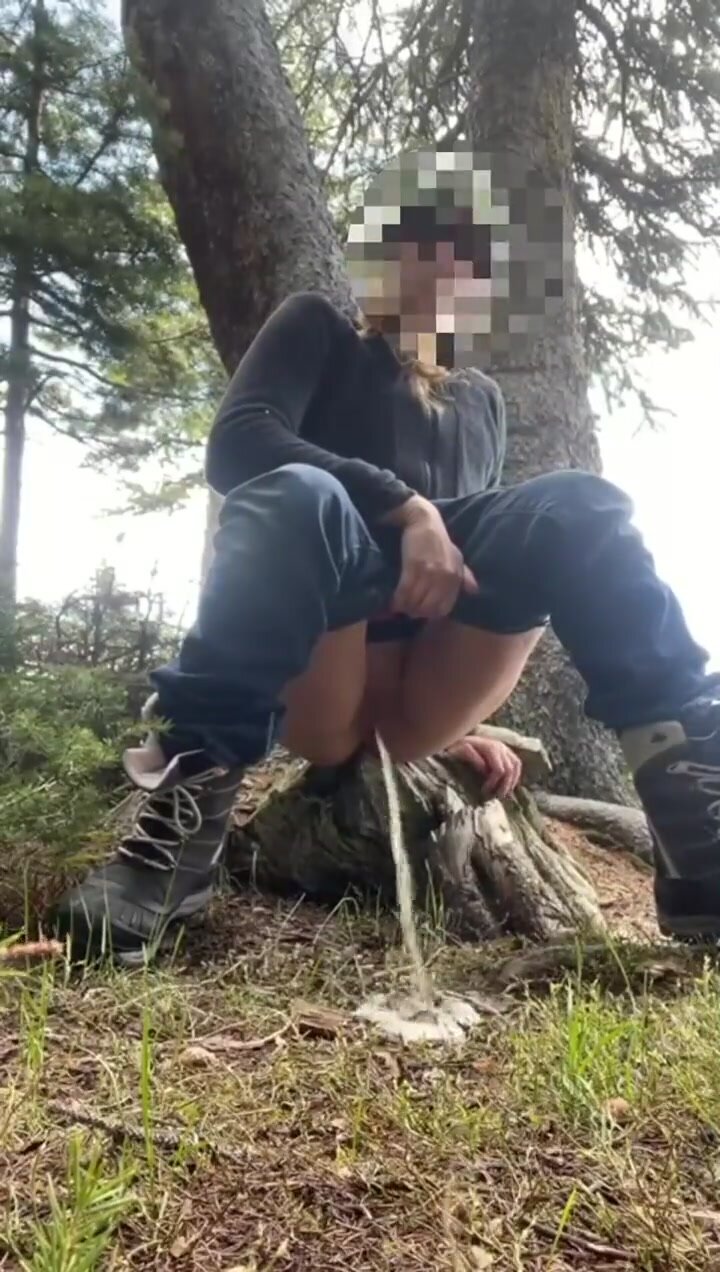 Girl pees off a tree stump