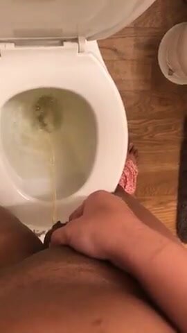 Girl holds her pussy like a dick piss in toilet
