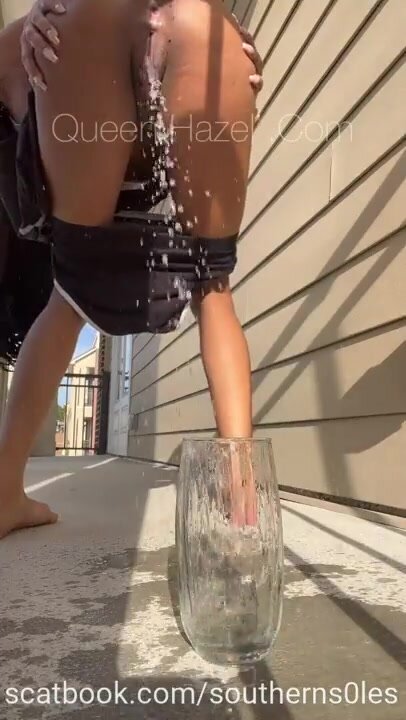 Cute ebony tries to pee in glass