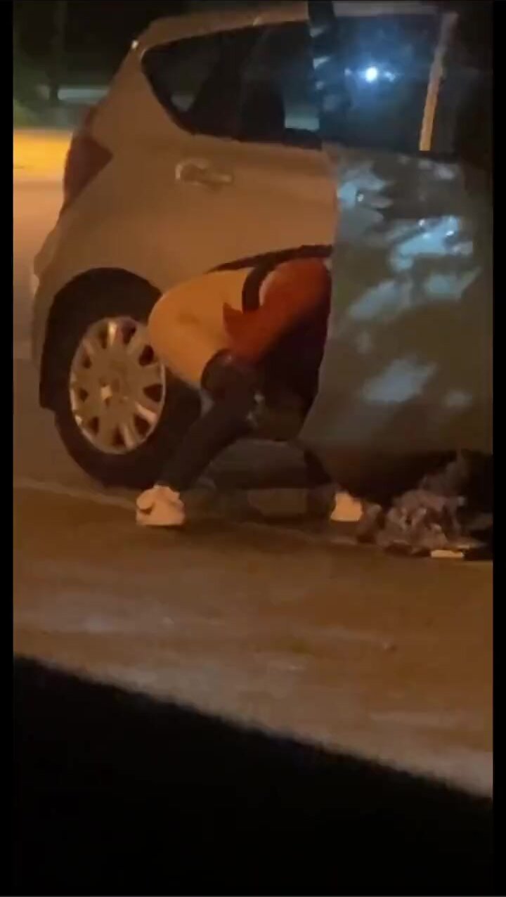 Sexy chick peeing in parking lot hides behind car door