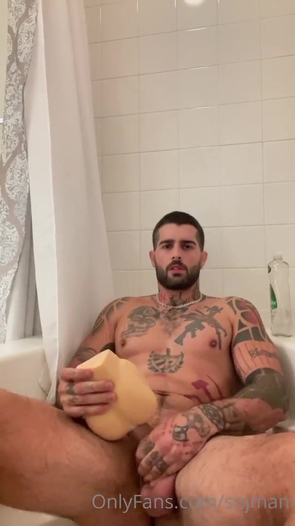 handsome tattooed man jerks off with sex toy