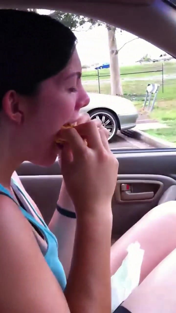 Fit athletic girl shoves whole cheeseburger in mouth