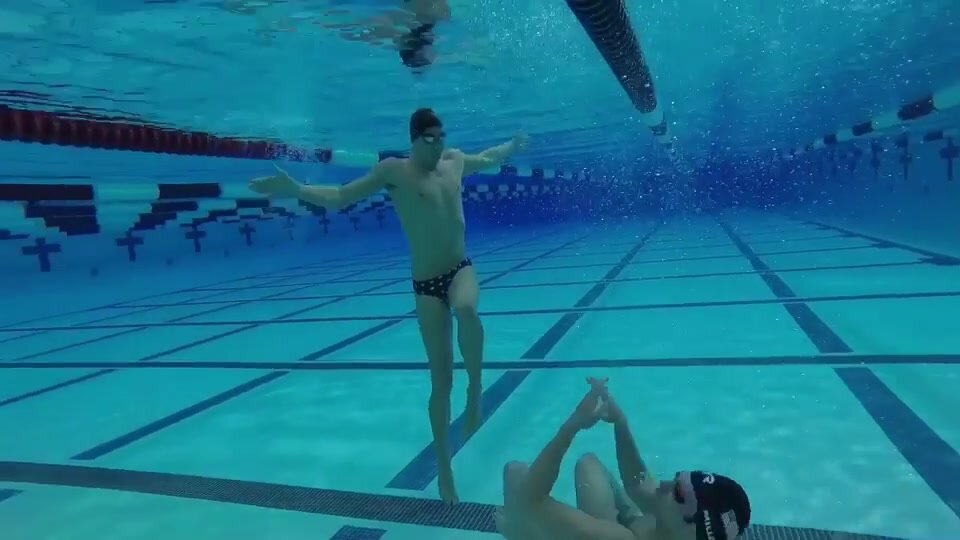 Swimmers goofing underwater in speedos