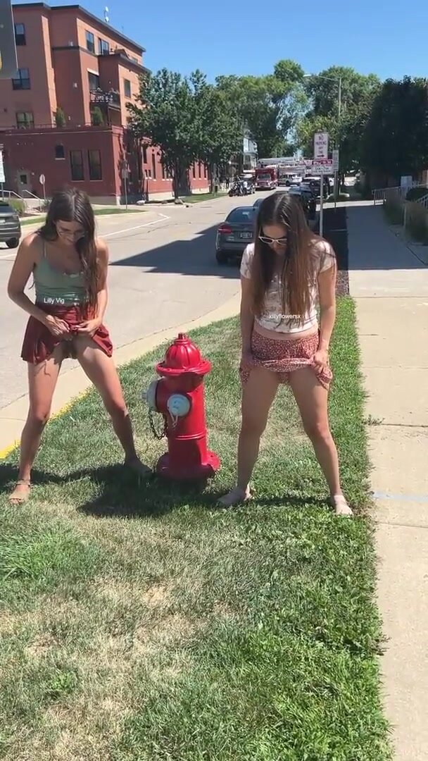Girls pee standing by fire hydrant
