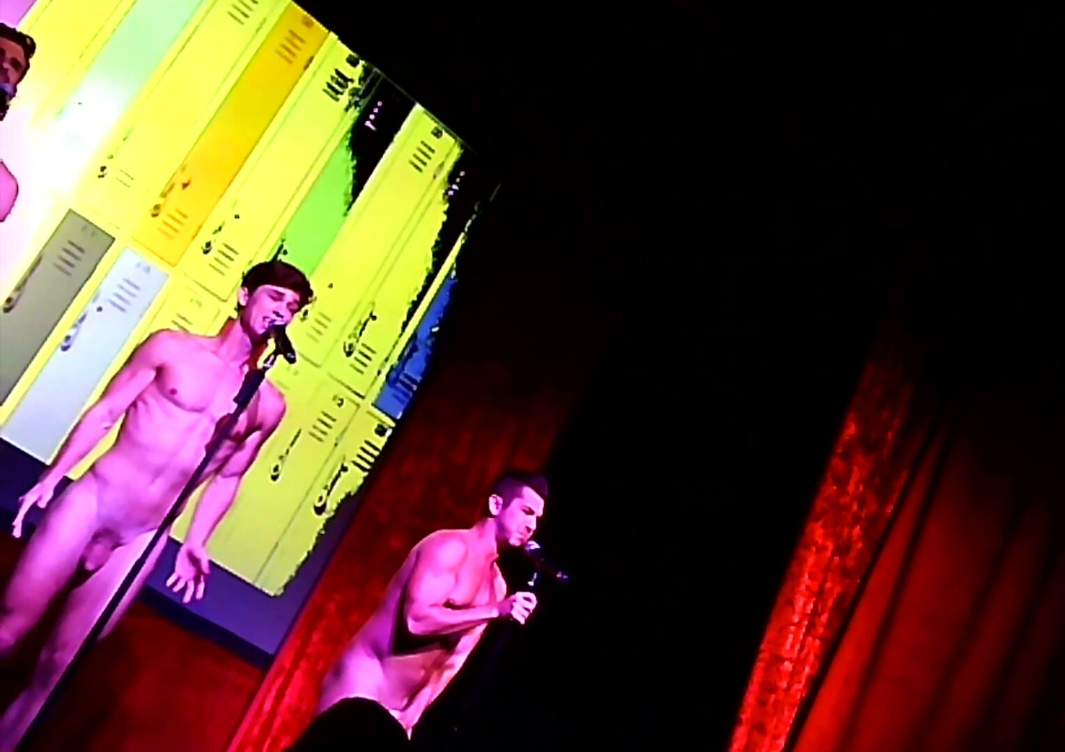 Hot guys perform nude on stage.