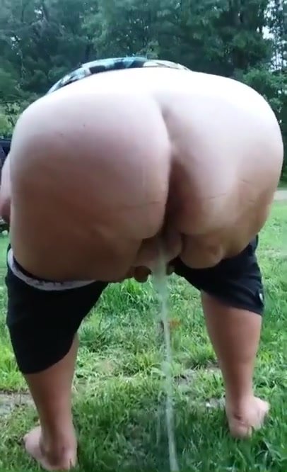 Big ass granny bent over peeing in the grass