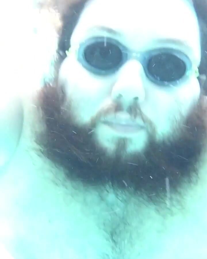 Beefy guy bubbling underwater in tight speedo