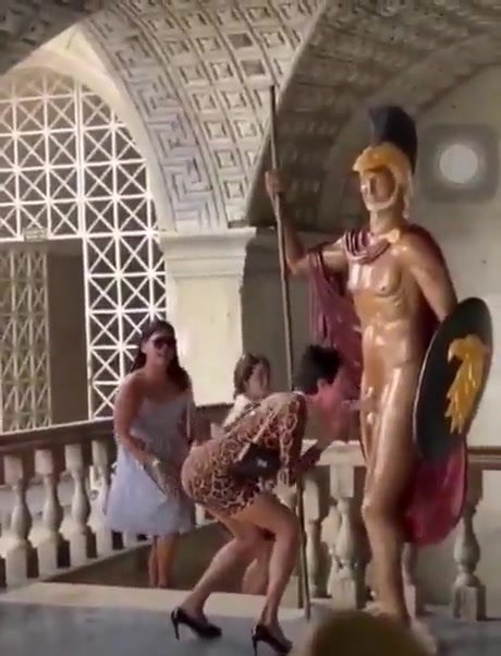 Horny girl rubs on a statues cock