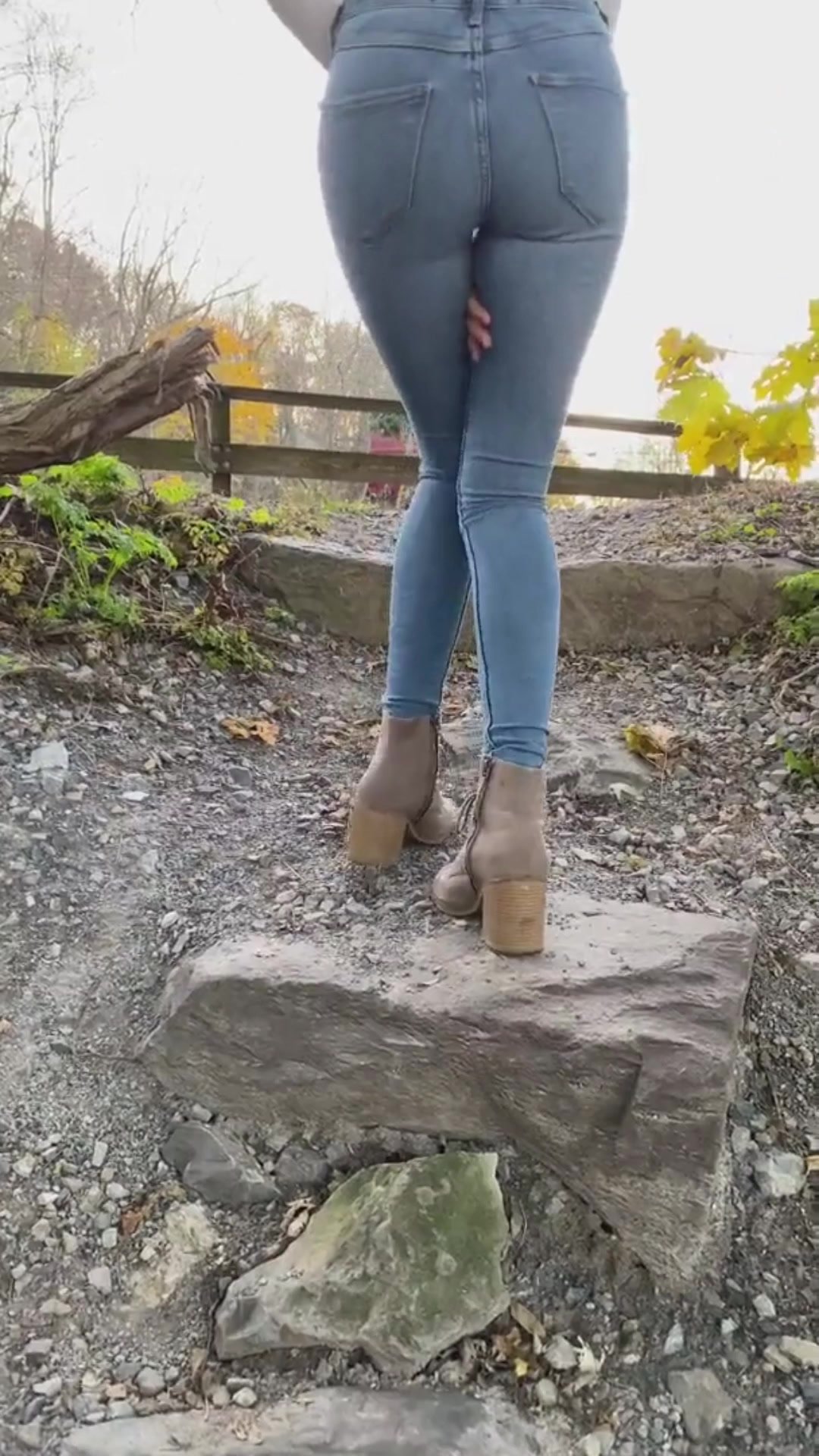 Girl wets her jeans on a rock
