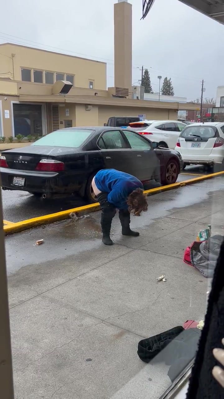 Lady takes a piss in front of a business