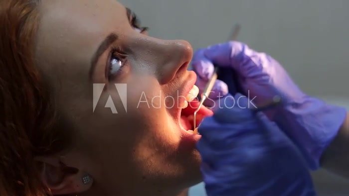 Dental examines teeth female patient