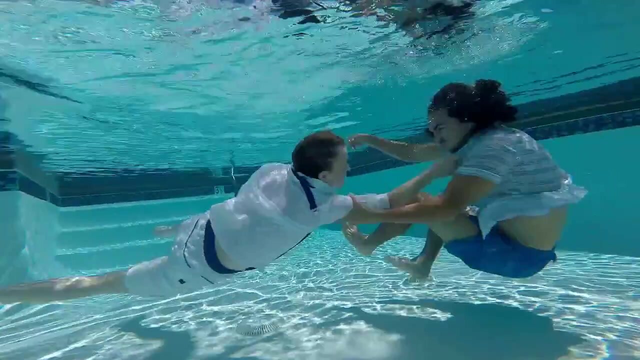 Fighting clothed and barefaced underwater in pool