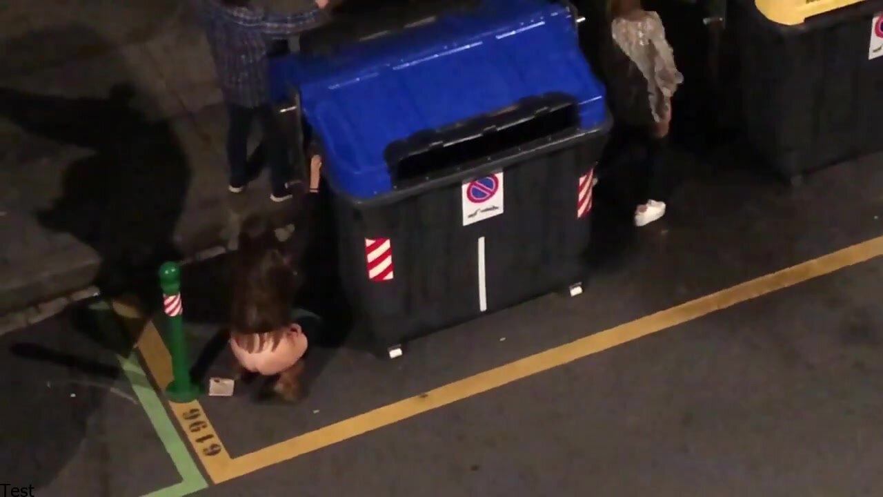 Girl peeing behind a dumpster