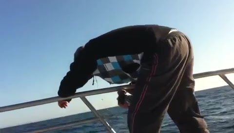 Seasick man vomiting over the railing