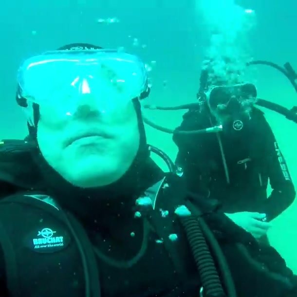 Arab scubadivers taking reg off underwater
