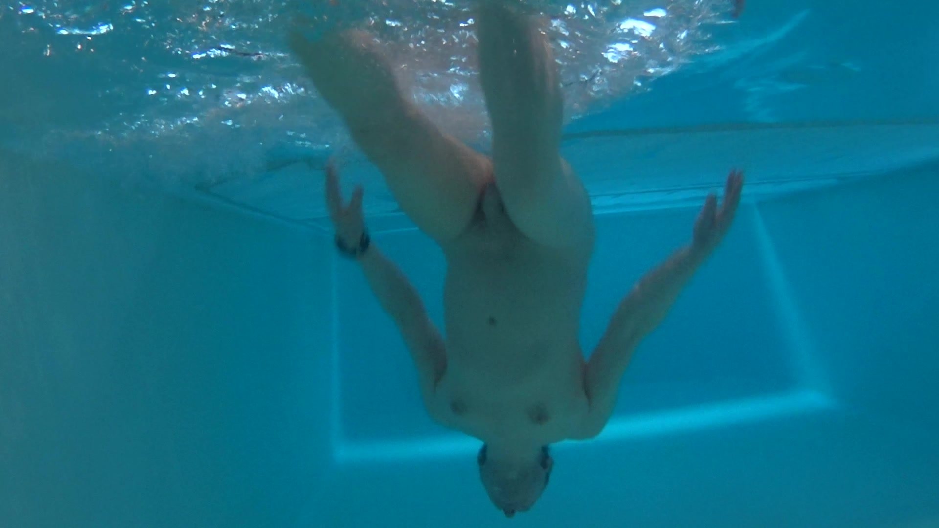 swimming nude in pool underwater