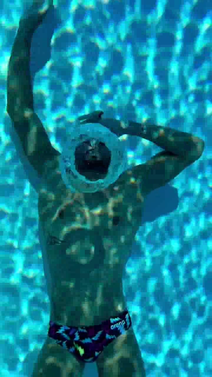 French fit swimmer blowing bubbles underwater