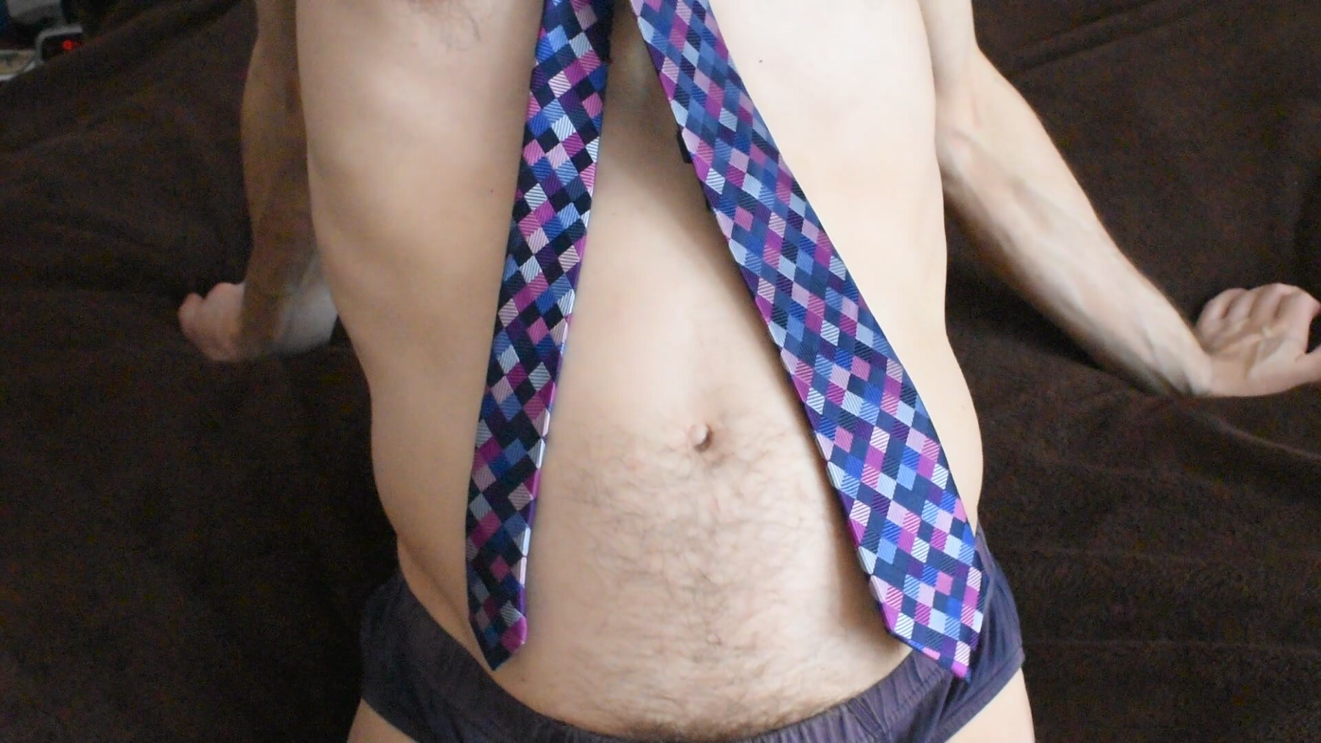 Shirtless guy wears tie and plays with his belly button