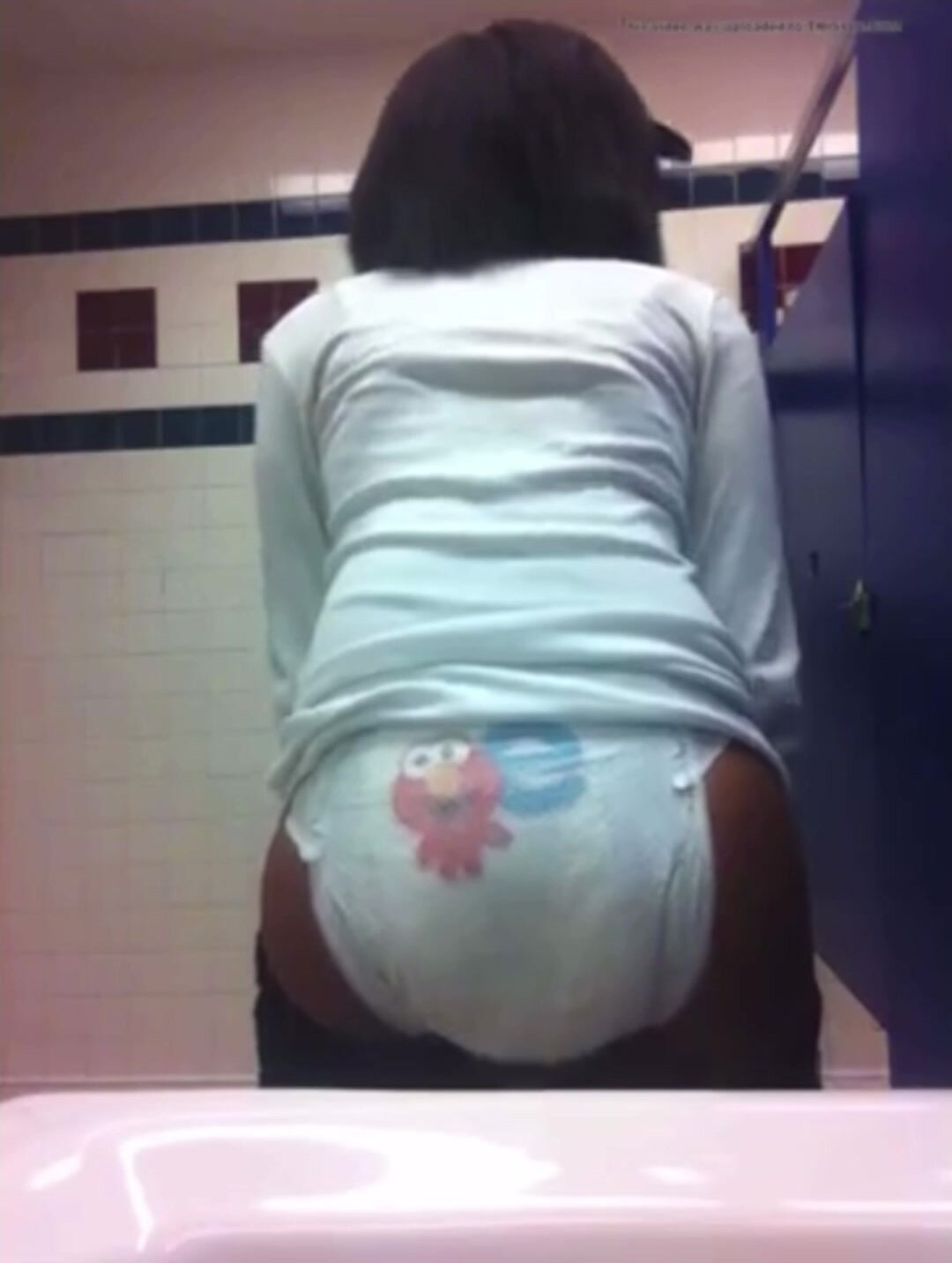 Girl poops herself in a diaper in a school restroom