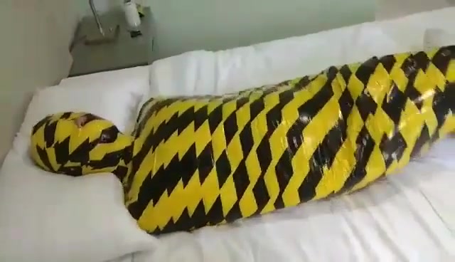 mummified in yellow black tape