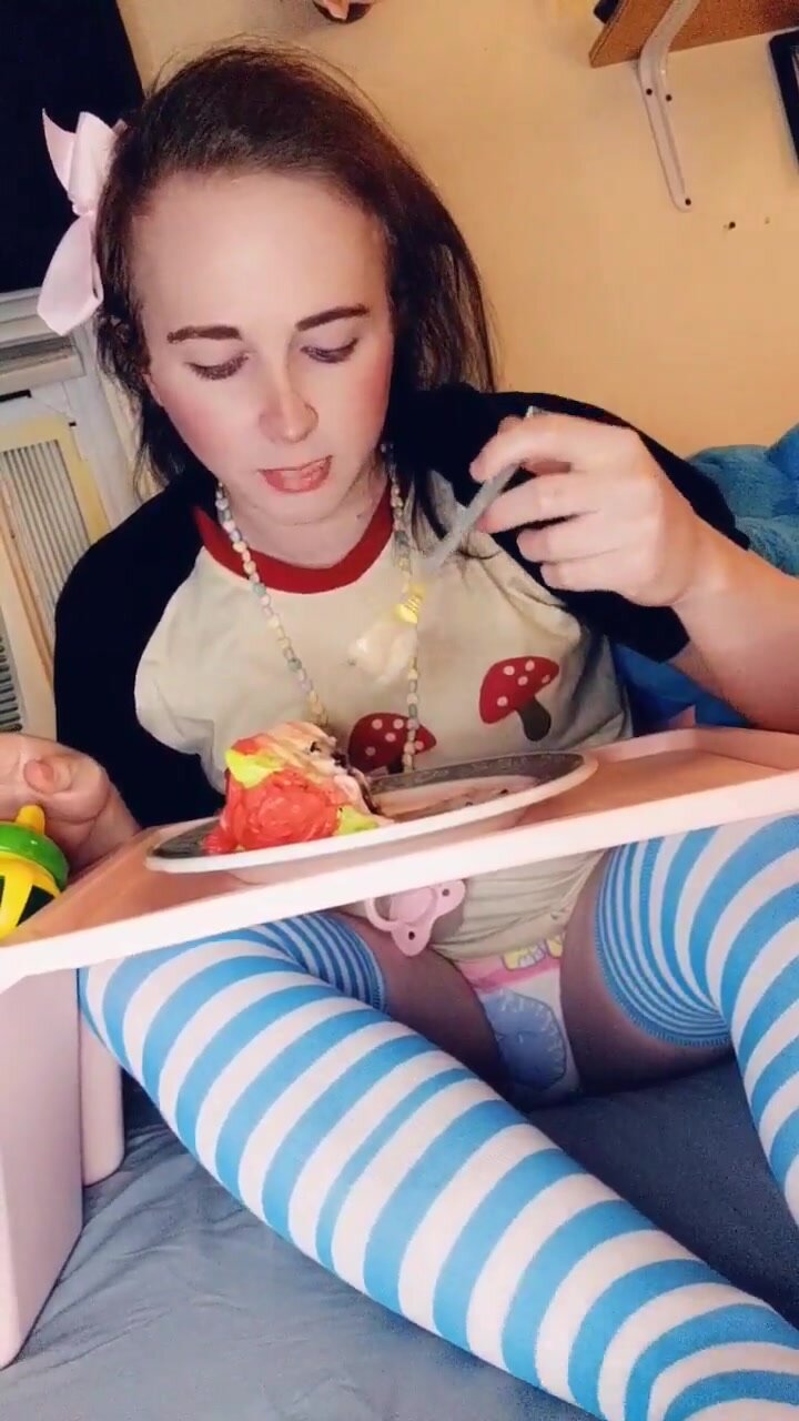 Baby eating cake in diaper with sippy cup