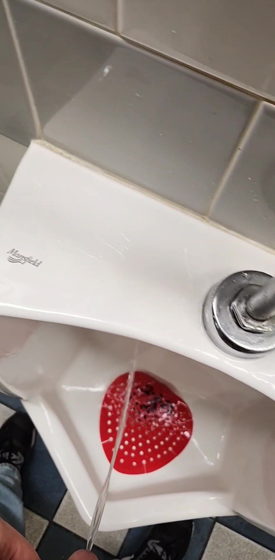Pissing across urinals
