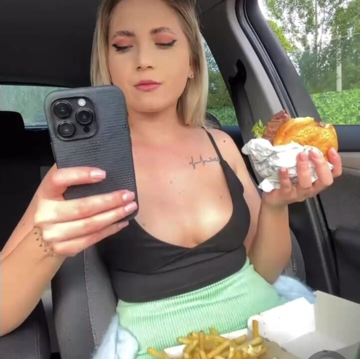 Blonde Slavic girl eating and burping in her car