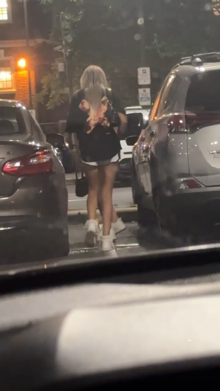2 girls pissing outside between cars outside or bar