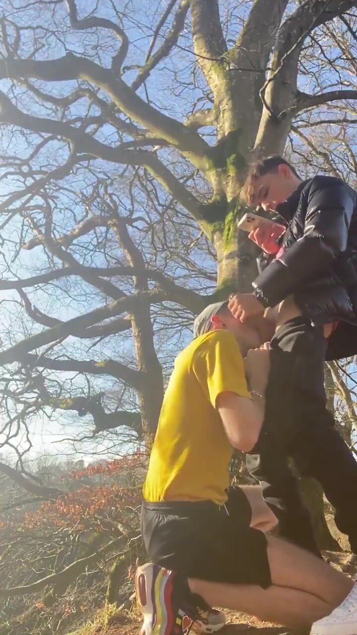 He sucks his friend in the nature.