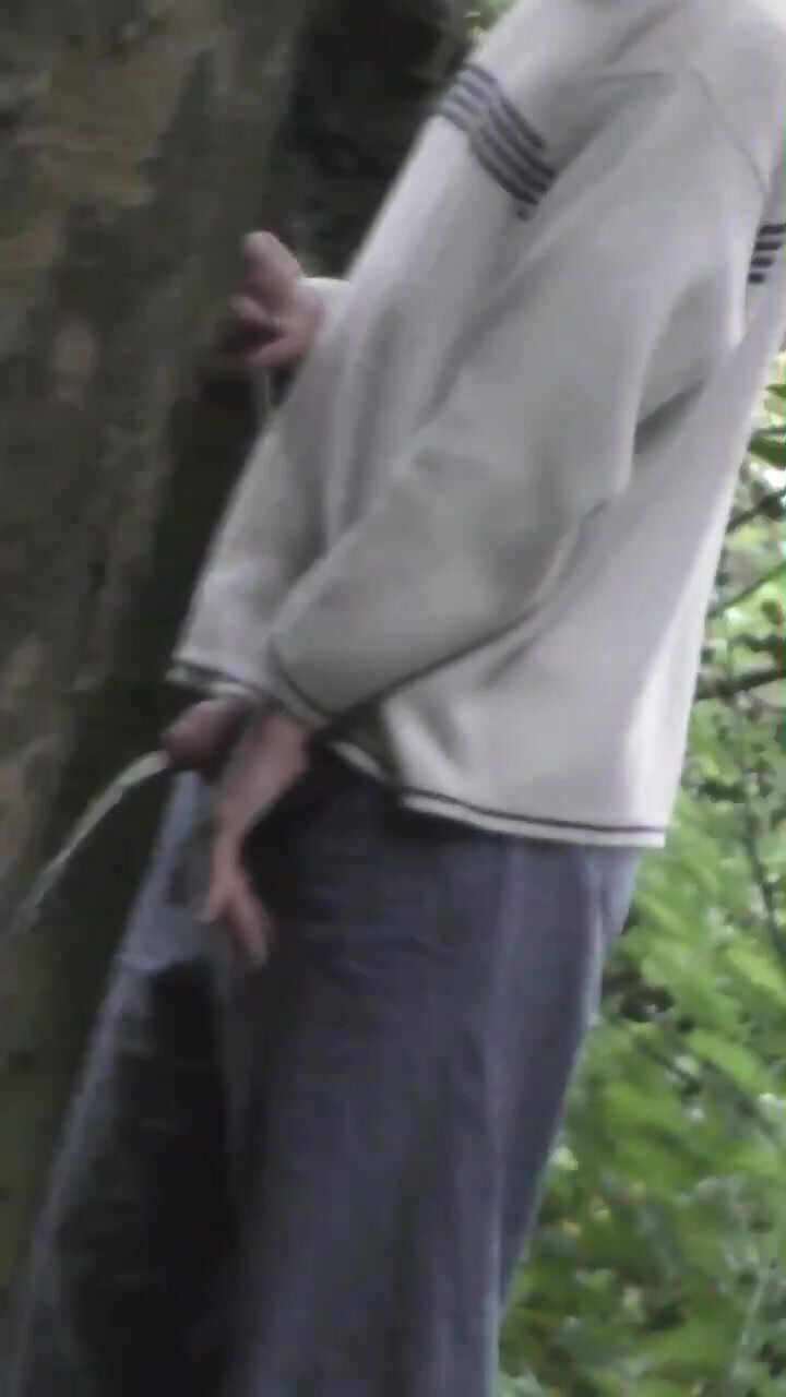 Boy pissing on a tree