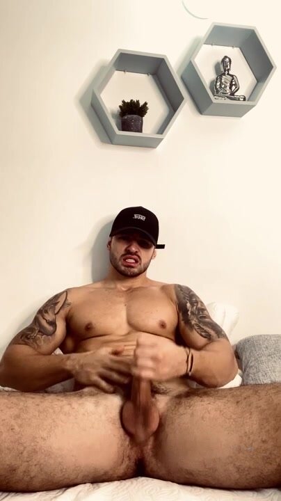 muscular hunk in baseball cap jerks off
