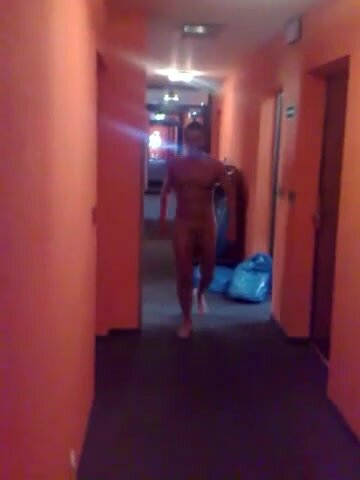 Hung man walks down hotel hallway naked