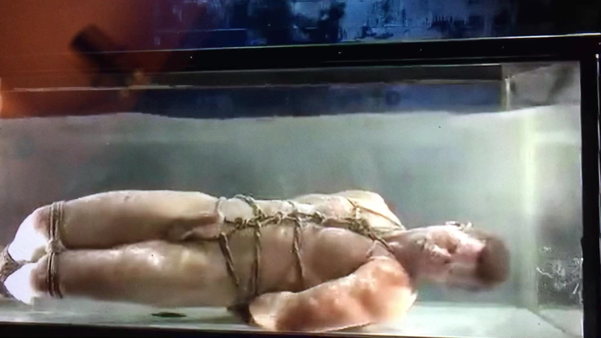 Hot guy chained and bounded in a water tank