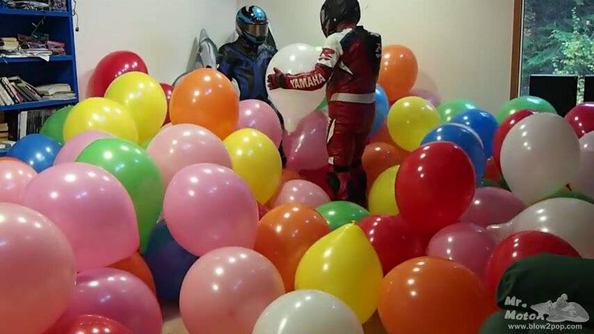 2 men busting a room full of balloons