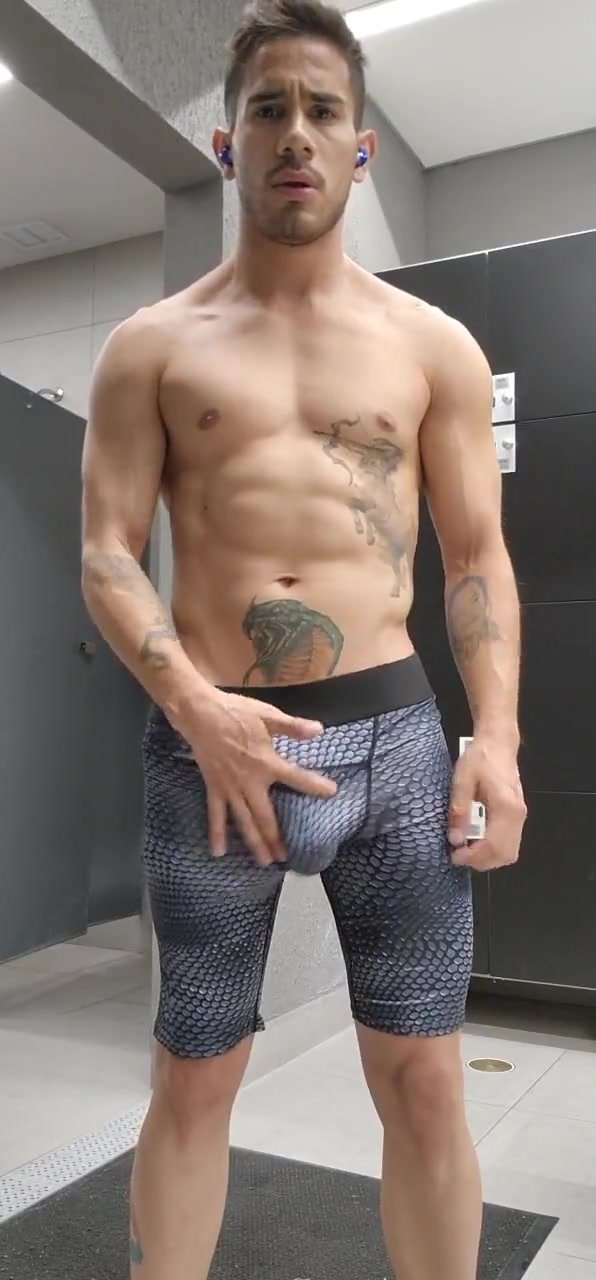 Young handsome tattooed man showing off his anaconda in