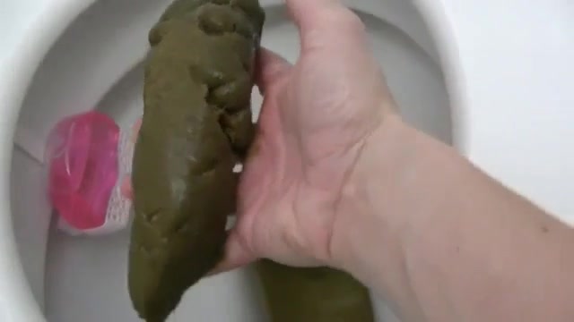 Dropping a big turd while fingering her cunt