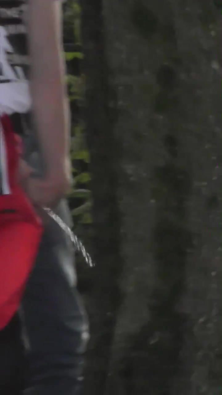 Mullet guy taking a piss against a tree