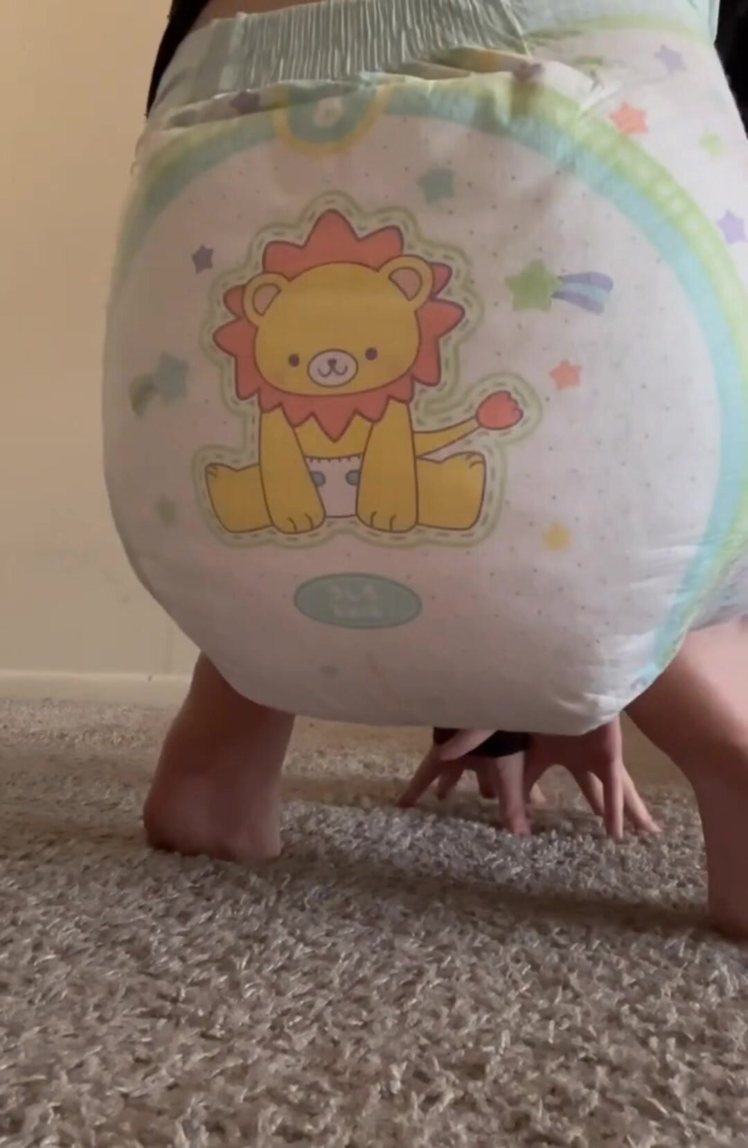 Baby girl messes her diaper and squishes in it.