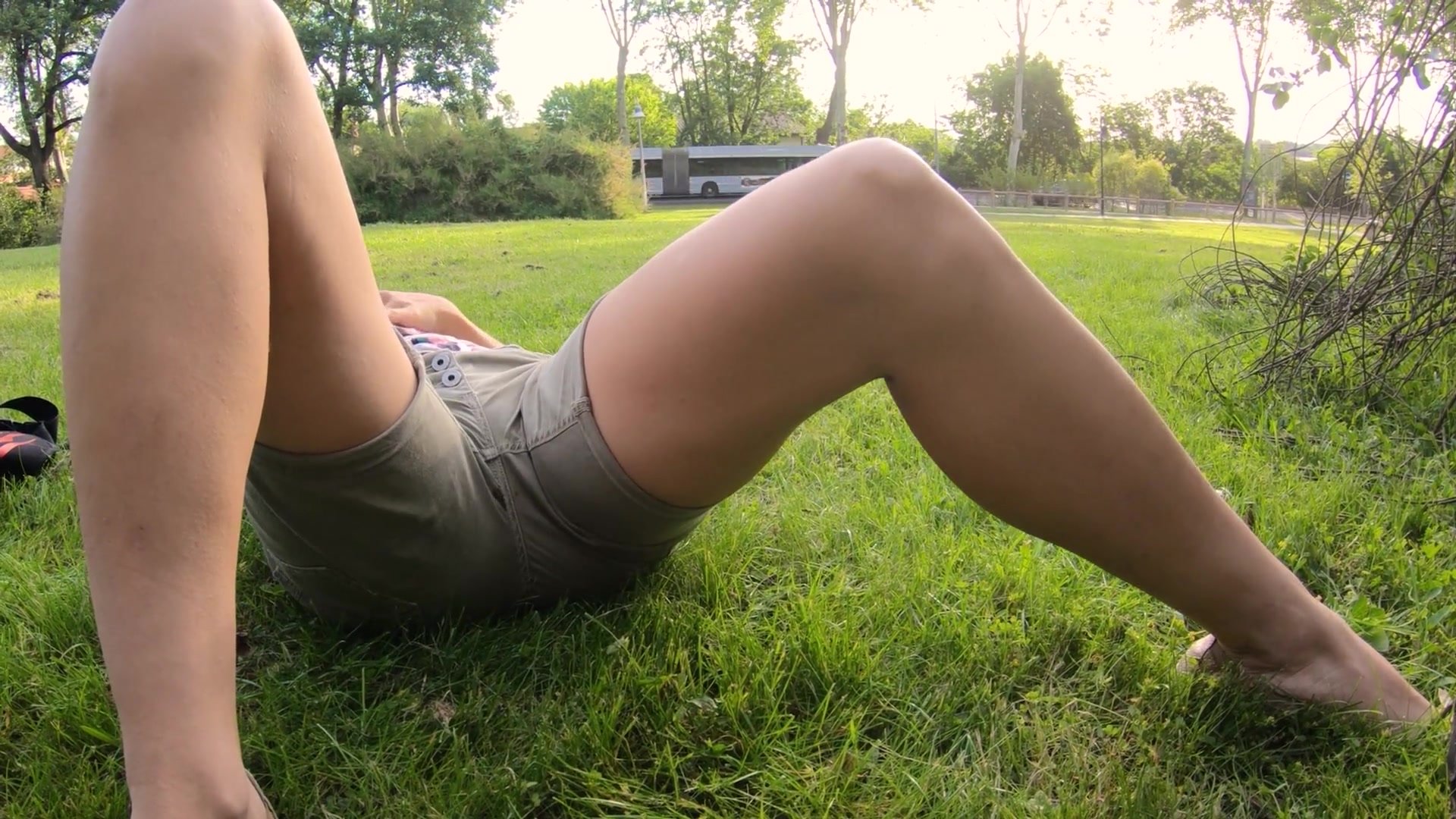 Girl pees her shorts resting in the grass