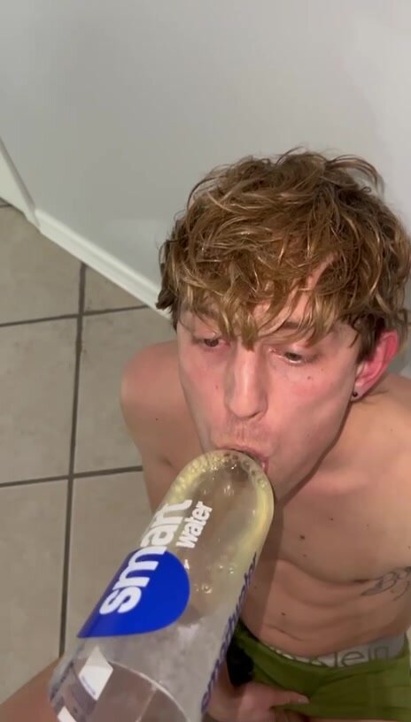 Blond boy drinking by a makeshift funnel