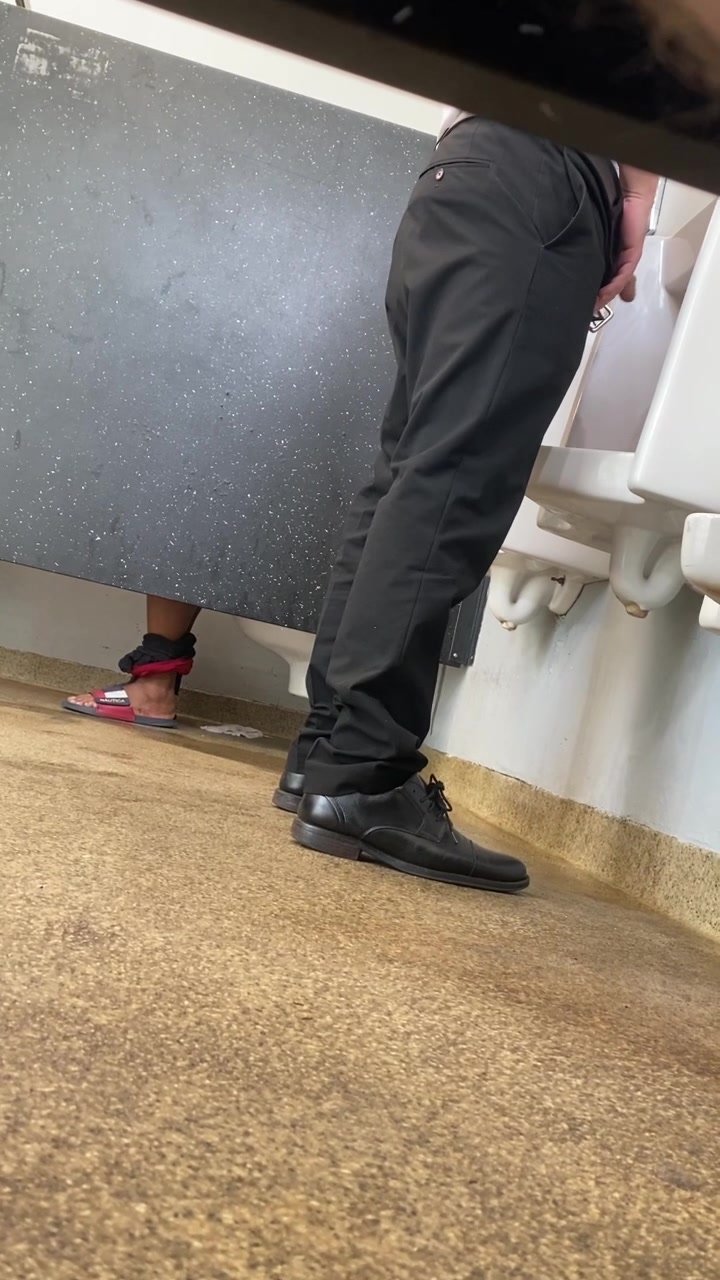 Business man at urinal shows off