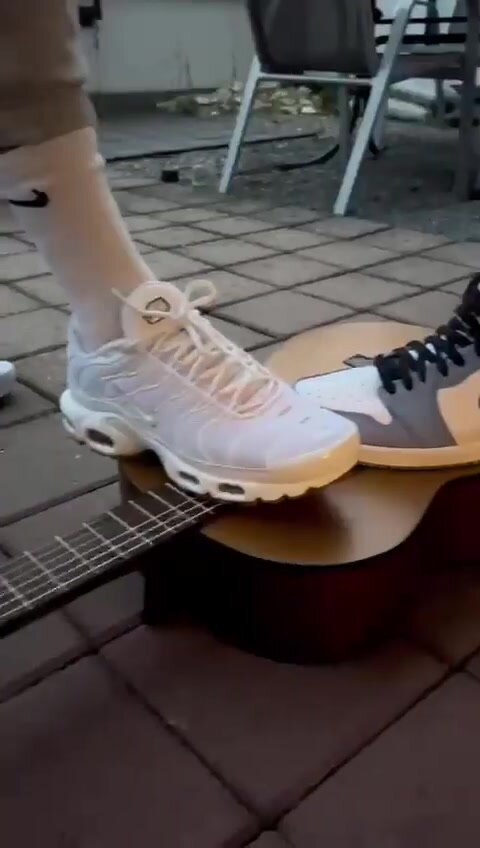 2 Guys Stomping and Crushing a Guitar under Sneakers