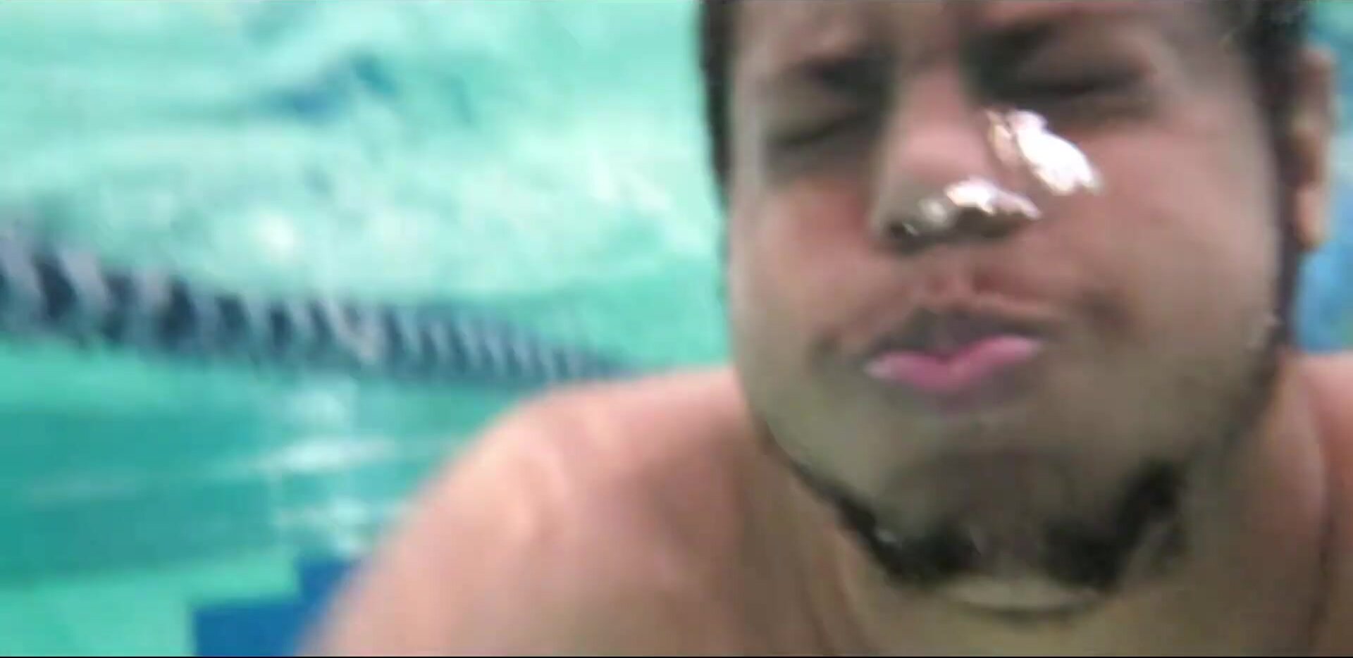 Beefy Black Man Swimming Underwater In Pool