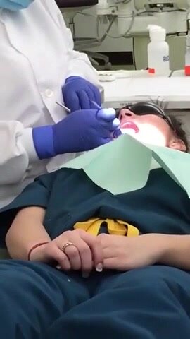 Girl has her teeth cleaned by a teacher