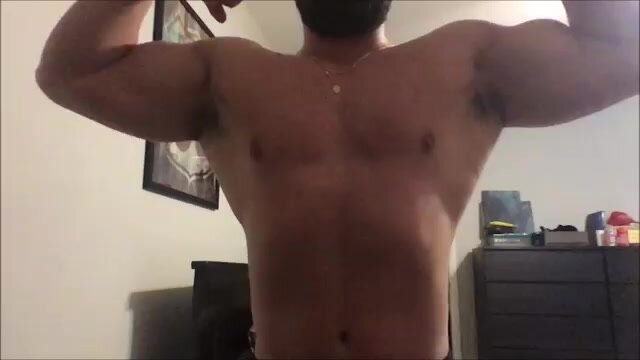Latino hunk flexing biceps lats and legs