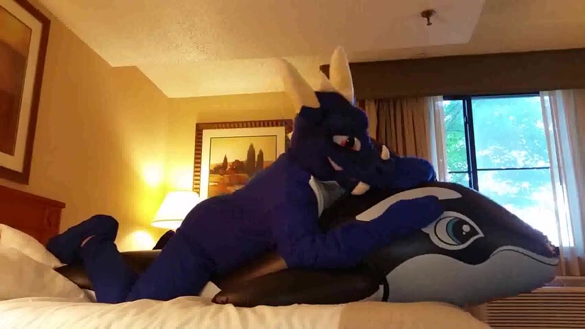 Dragon cuddeling a inflatable whale